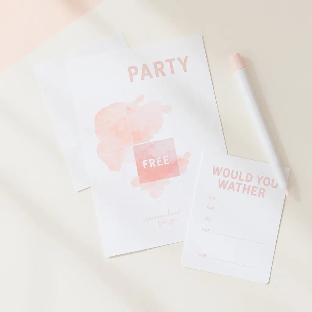 A flat-lay of three printable Bashberry party cards: bingo, scavenger hunt clue, and would-you-rather prompt